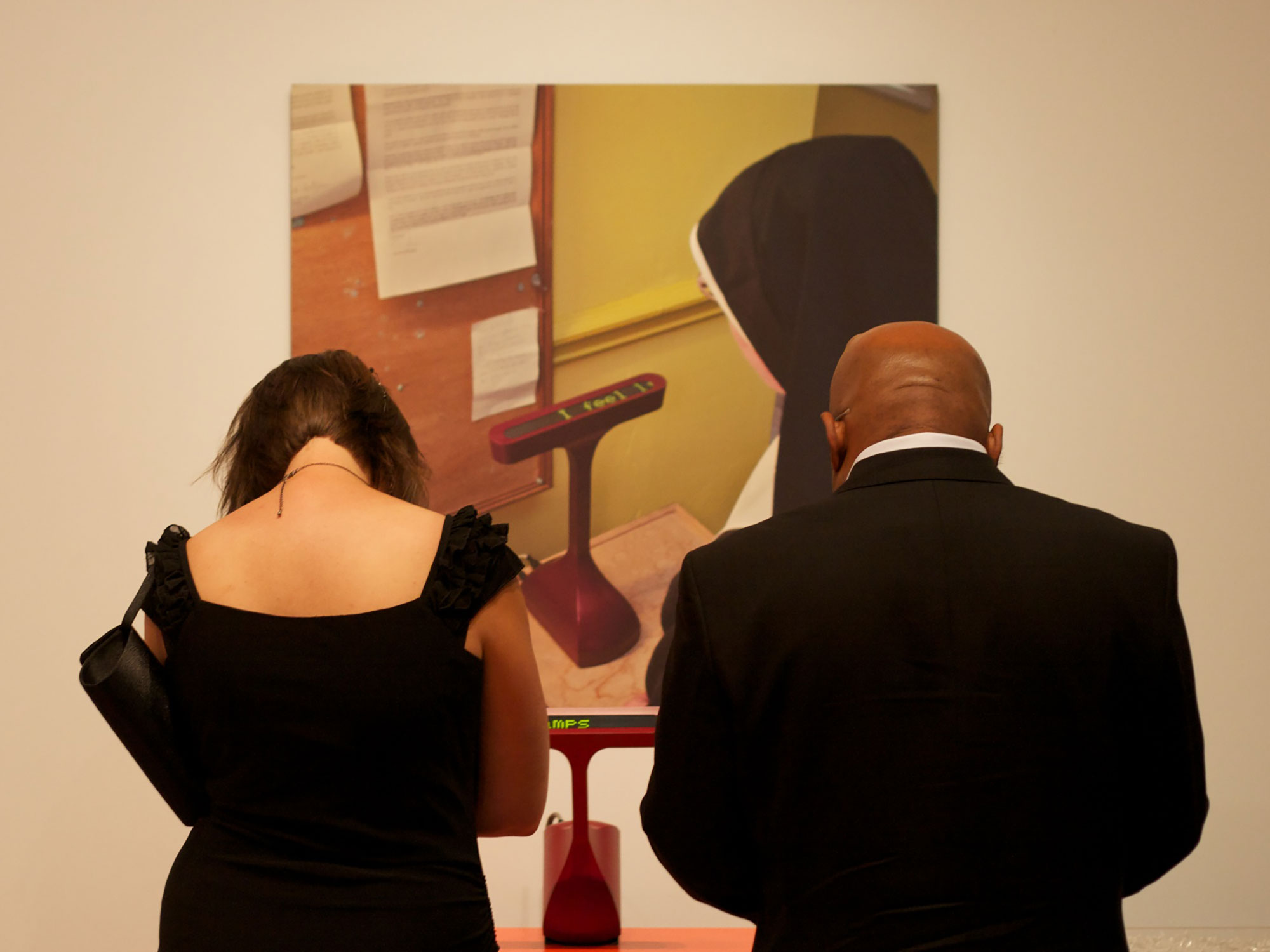 A photograph of visitors viewing the Prayer Companion at MoMA